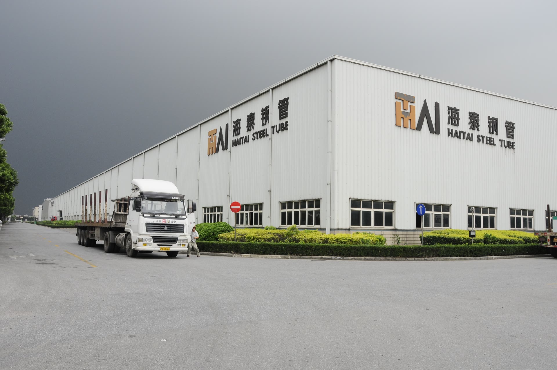 海泰钢管厂房外立面，标有 HAITAI STEEL TUBE 品牌标识